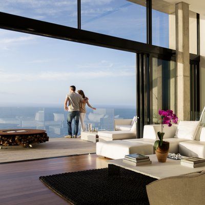couple staning in front of large wall to ceiling penthouse window